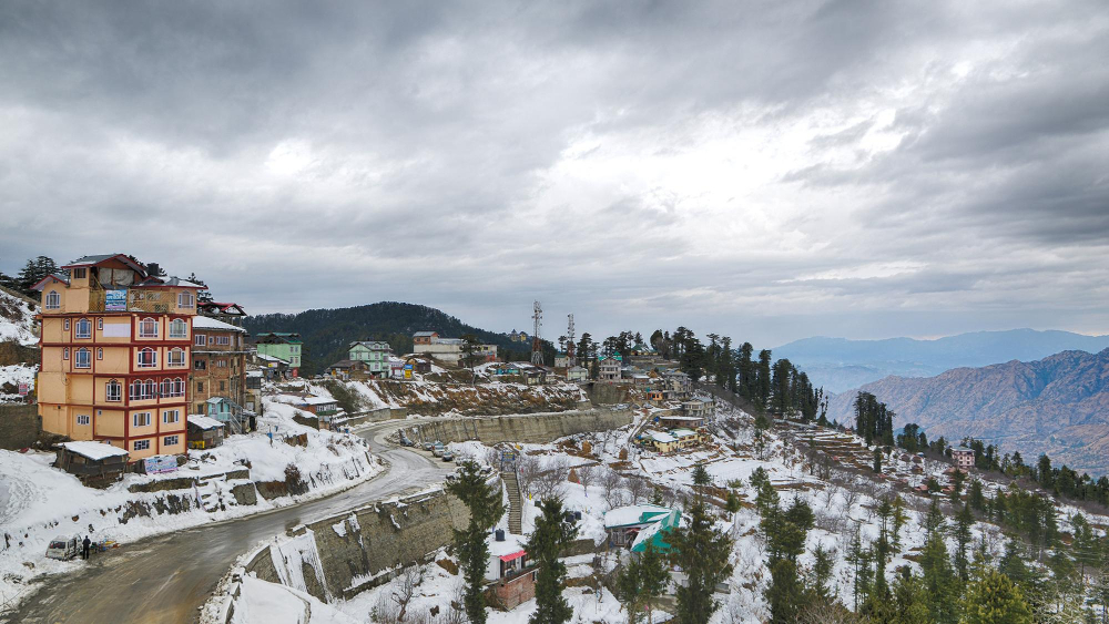 Snow covered pine trees and colonial buildings along Mall Road Shimla during a weekend getaway