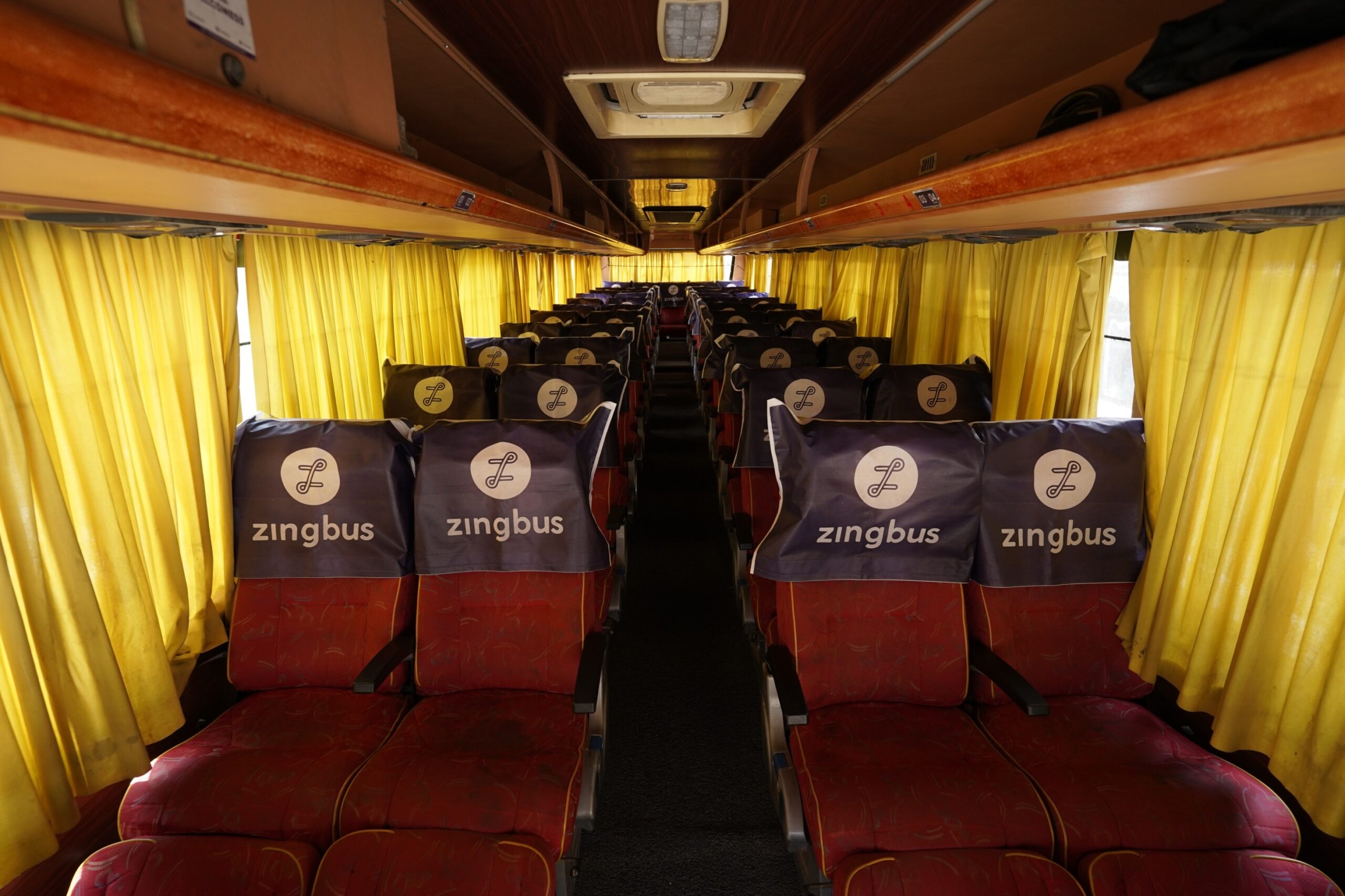 Traveller comparing a sleeper bus berth and an AC seater bus seat before booking an intercity journey