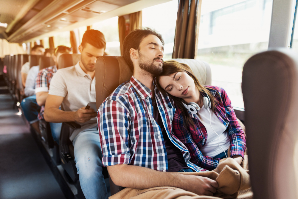 Traveller sleeping comfortably with neck pillow and eye mask on overnight bus in India