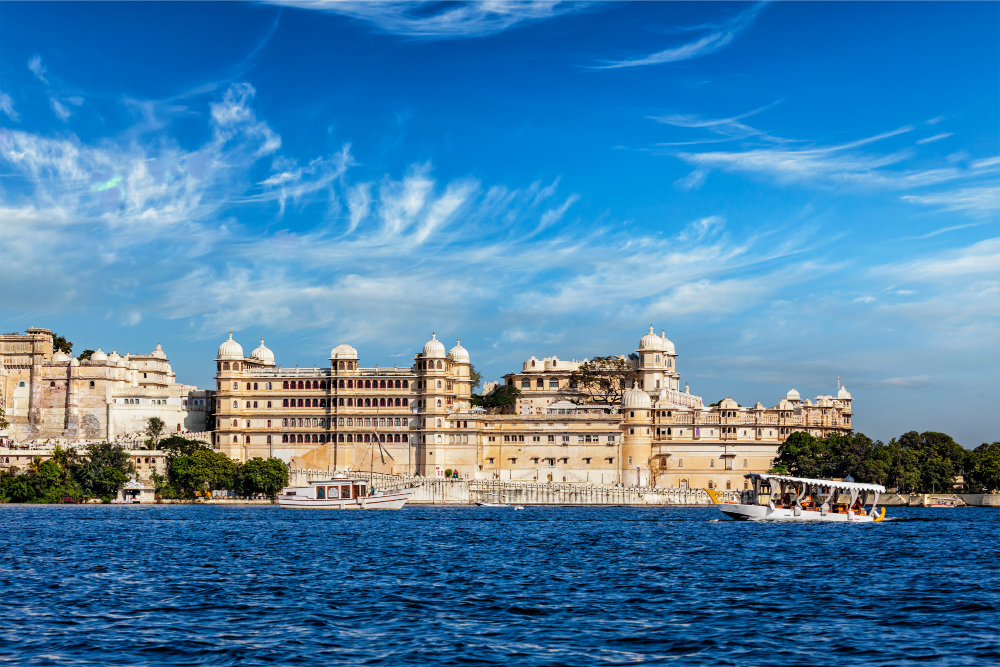 Places to visit in Udaipur — City Palace and Lake Pichola at dusk with Aravalli hills in the background
