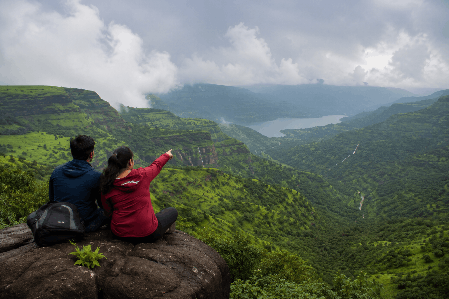 Travellers overlooking green Sahyadri hills on a weekend trip from Pune