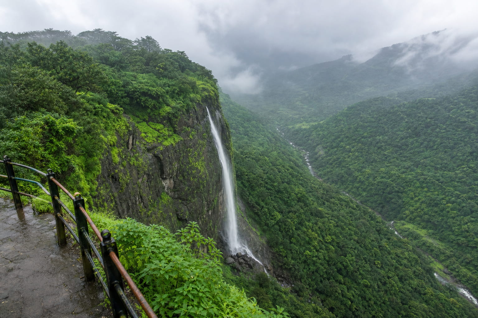 Misty green valley and waterfall view at Tiger's Leap viewpoint in Lonavala monsoon
