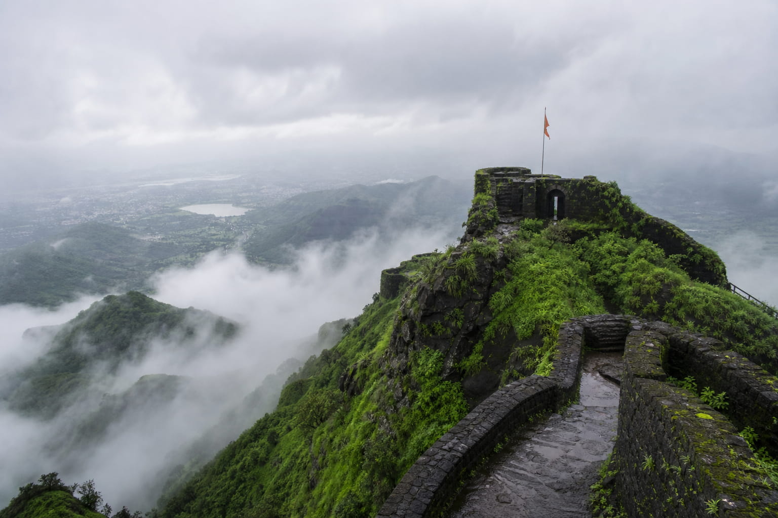 Sinhagad Fort hilltop in monsoon mist with Sahyadri valley view near Pune