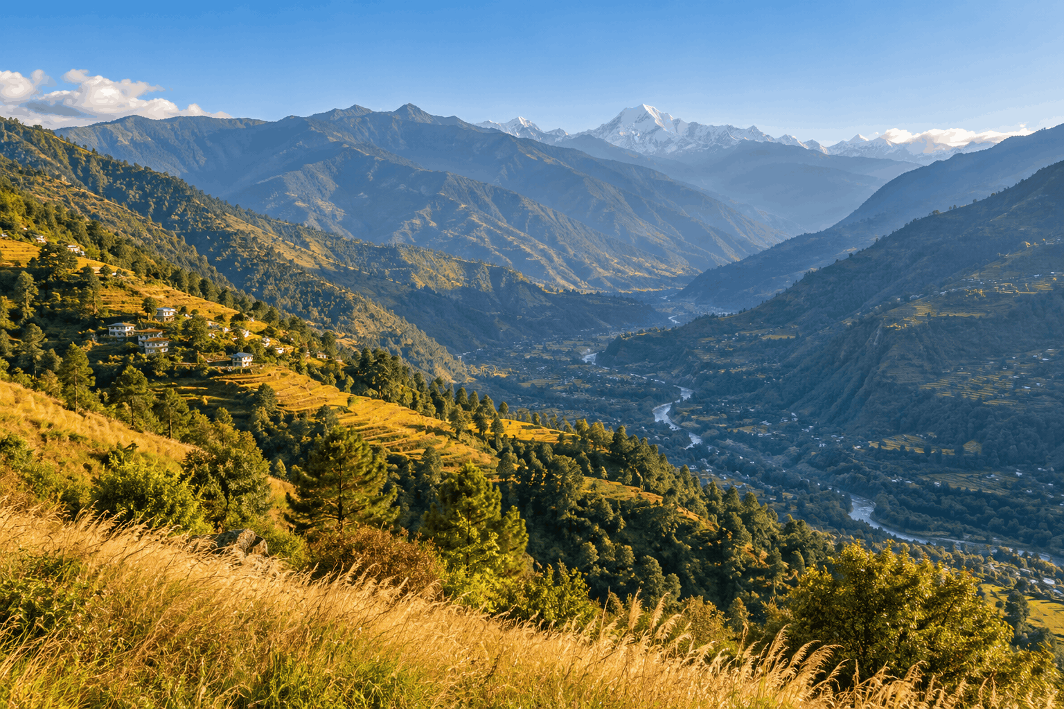 A valley view from a hill station with clear post-monsoon skies and green slopes turning golden in October